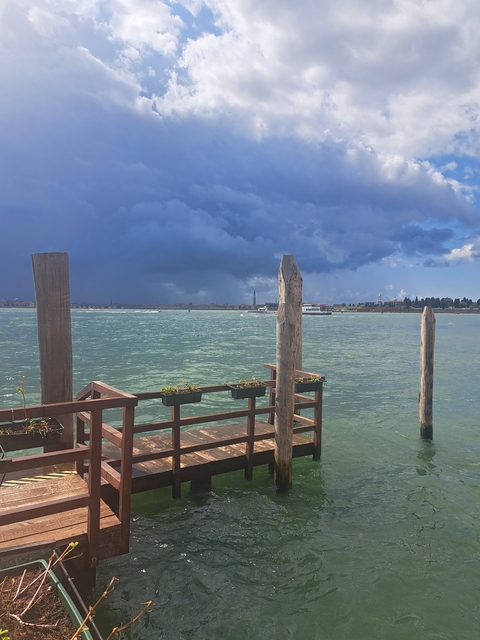 Scenic waterscape with wooden structures on a cloudy day.