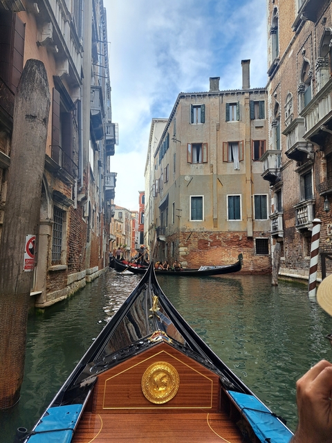 Gondolas navigating through narrow canals flanked by buildings.
