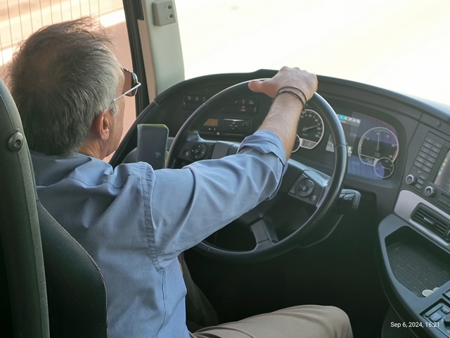 A person driving a bus or coach.