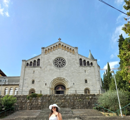       A church with a rose window and bell tower.
  