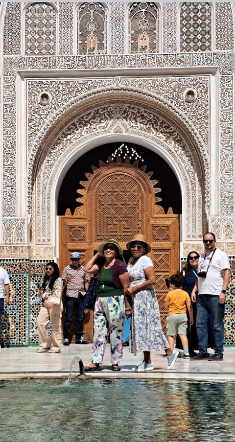 Group of people posing in front of an intricately designed entrance.