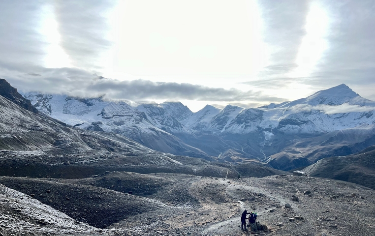 Snow-capped mountain range with a rocky foreground.