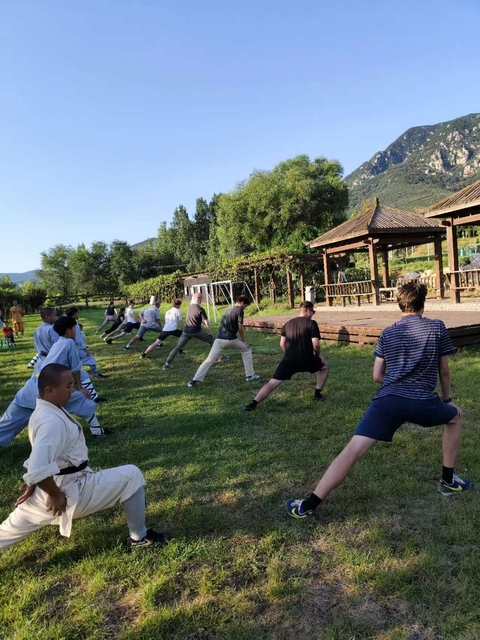 A group of people practicing martial arts outdoors.