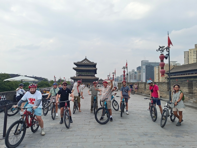 Group of people cycling on city walls with skyscrapers in the background.