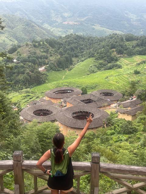       Scenic view of circular earth buildings in a lush green landscape.
  