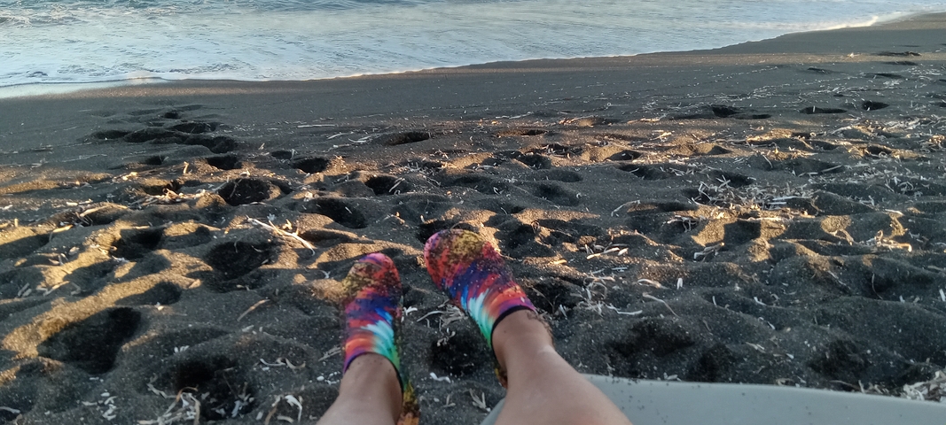 A view of a beach with colorful socks on the sand.