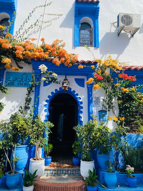 A building facade with blue and white decorations covered in flowers.