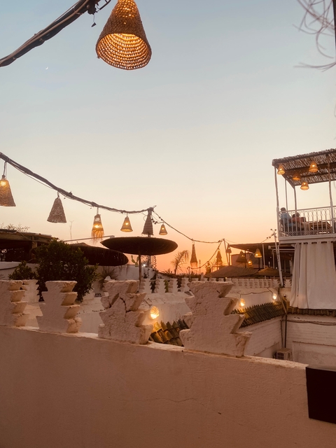 A rooftop restaurant with a view of the sunset.