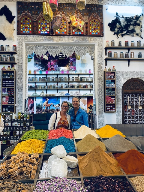Two people standing in a spice shop with decorative walls.