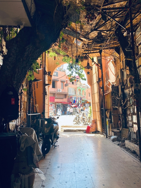       Bustling marketplace scene viewed through an archway.
  