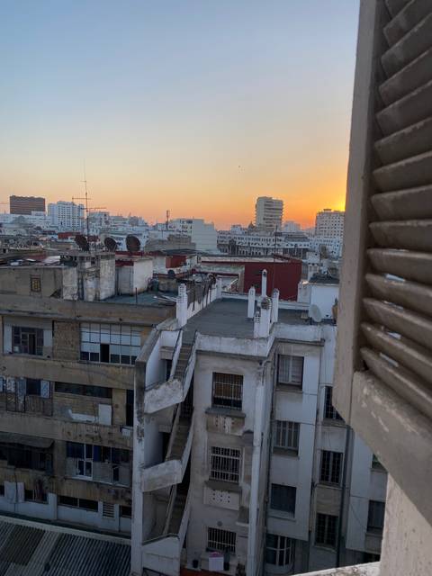 Urban skyline at sunset with a mix of modern and older buildings.