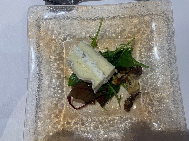 Plate with cheese and salad greens.