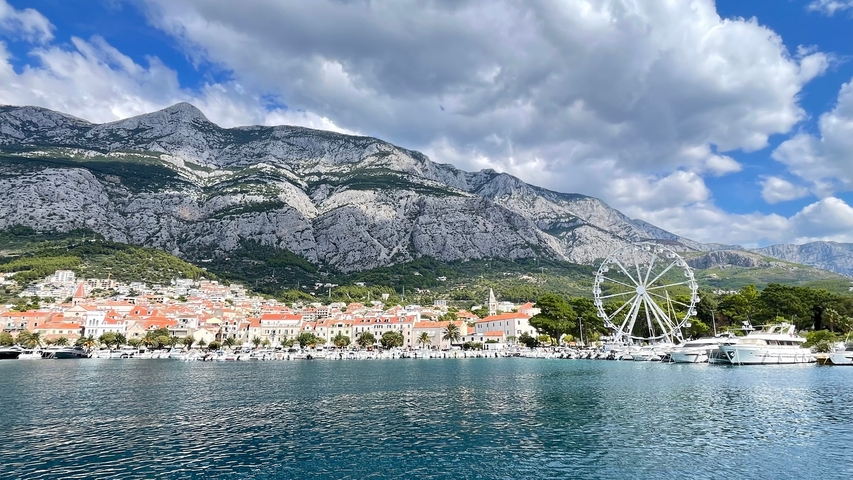 A coastal cityscape with mountains in the background.