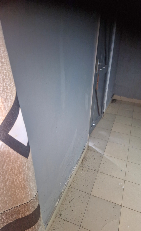 A plain wall and floor of a room.