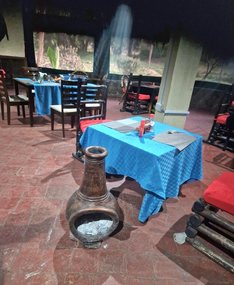 Tables and chairs arranged in a restaurant with a large decorative vase.