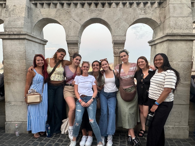 Group of women posing with an architectural background.