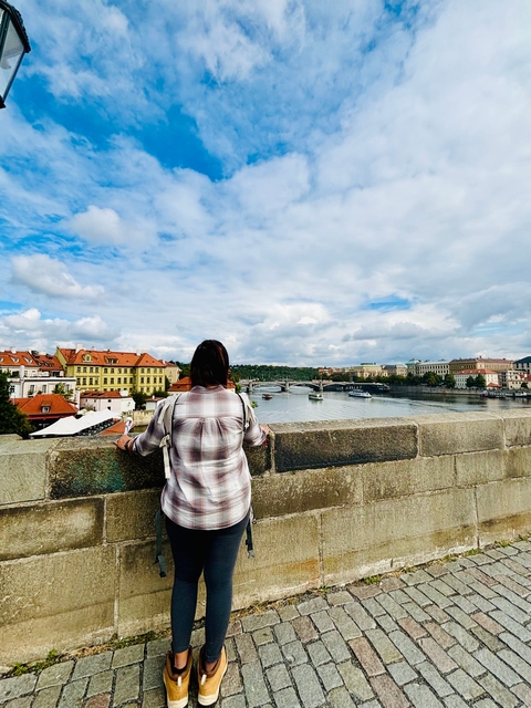 Woman looking over a river and bridges in a European city.