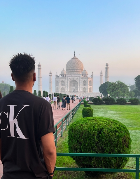       Person standing near the walkway to the Taj Mahal.
  
