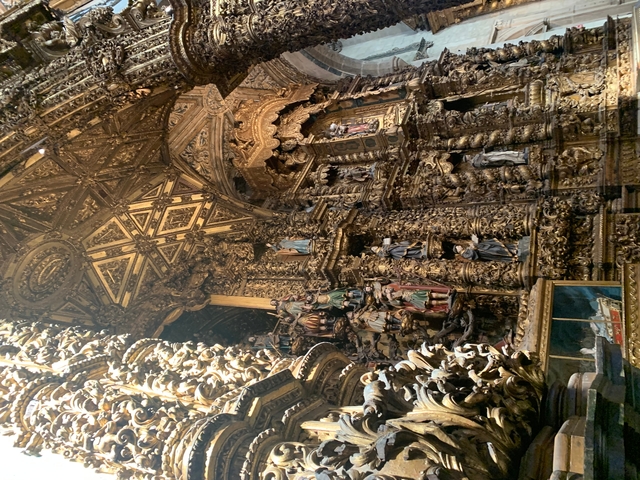       Intricate gold carvings and statues in an interior.
  