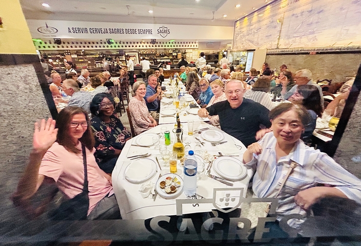       Group of diners at a large table in a busy restaurant.
  