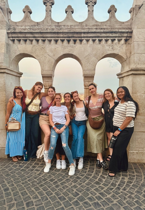 Group of women posing together with city view.