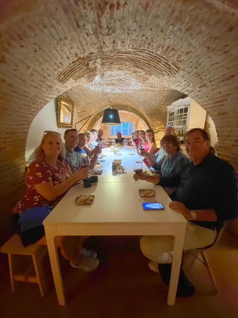 A group dining in an arched cellar-like setting.