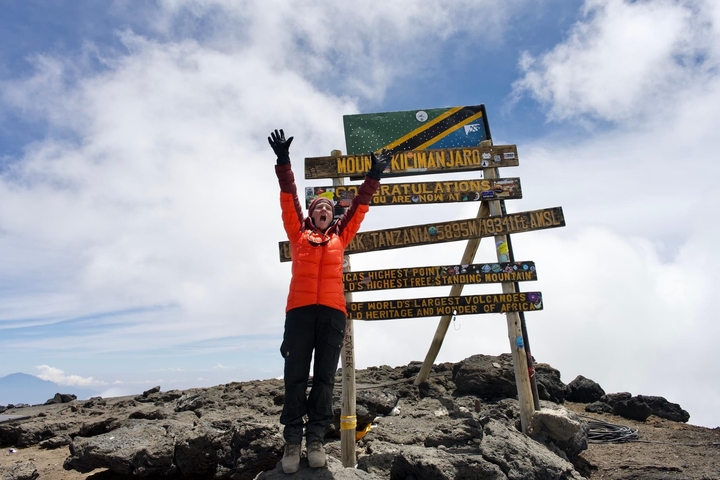 Person celebrating at the summit of Mount Kilimanjaro.