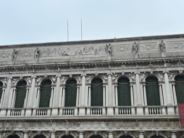       Facade with arched windows and detailed stonework.
  