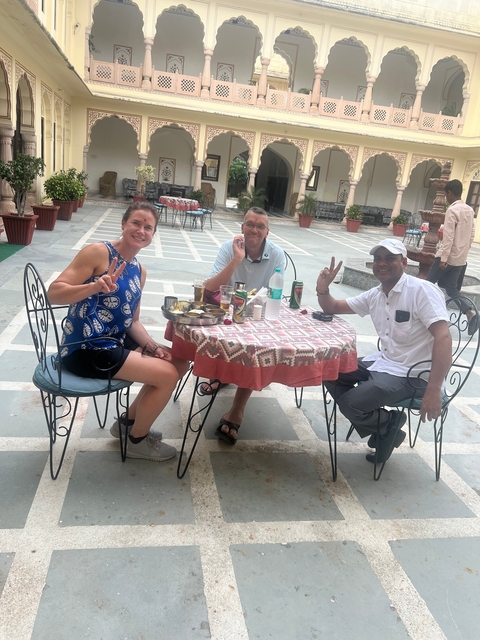 Group of people dining outdoors at a round table.