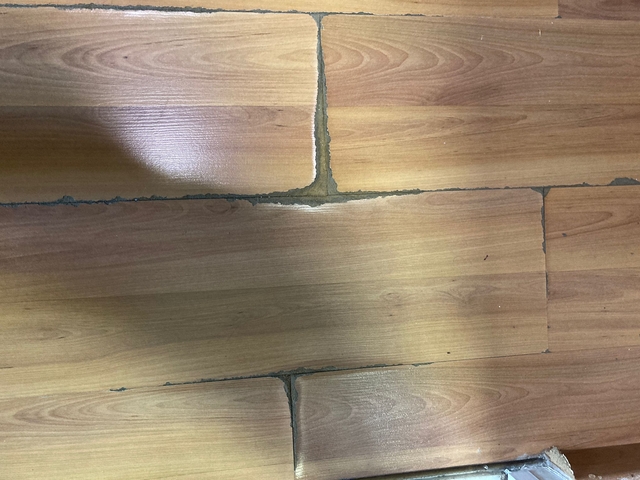 Close-up of wooden floor tiles with visible gaps.