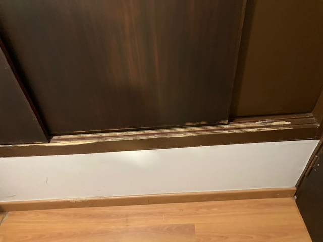 Image of a damaged wall base with wooden panels.