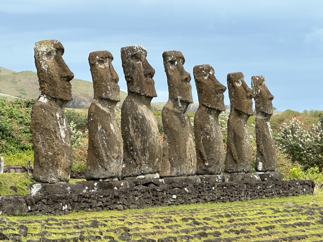 Row of large stone statues on a base.