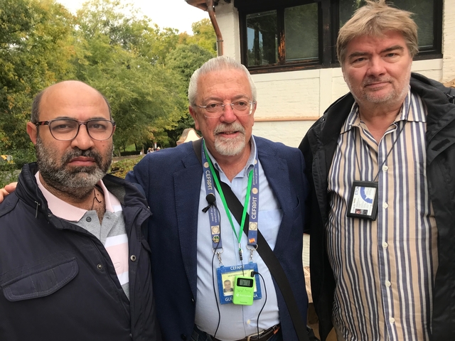 Three men posing outdoors.
