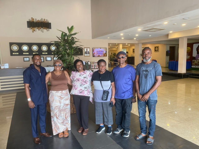       A group of people posing inside a hotel lobby.
  