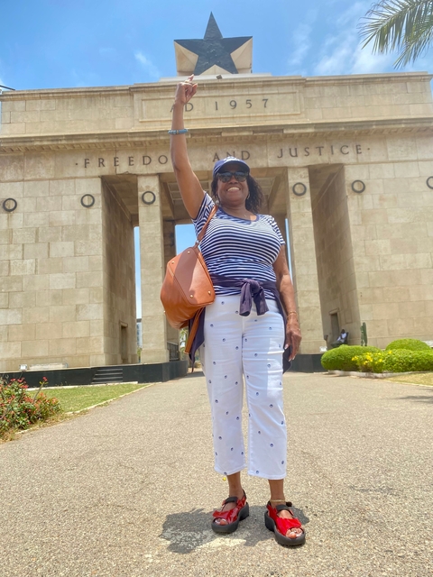       A person posing in front of a monument.
  