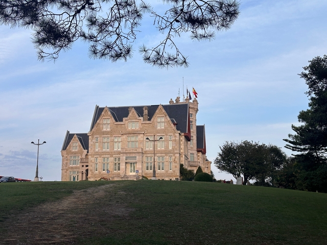       Large building with flags atop a hill.
  
