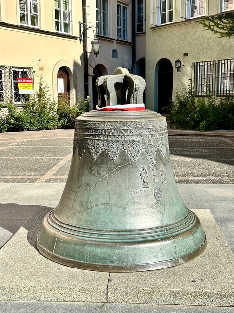       Large historic bell with inscriptions.
  