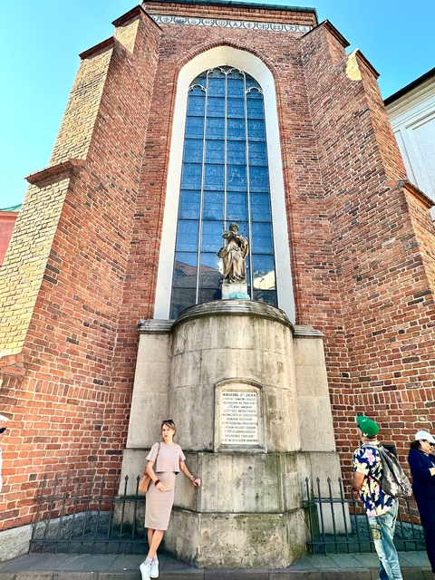 Brick church facade with a statue.