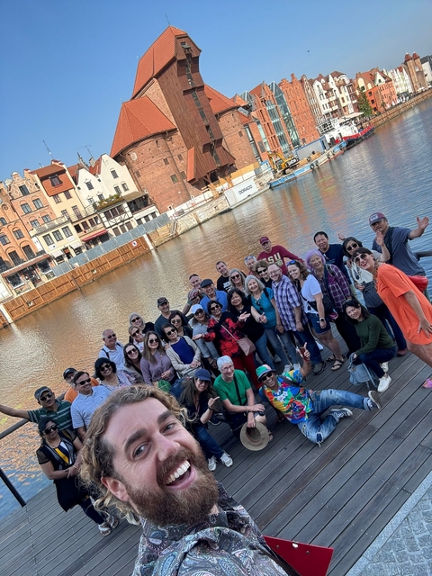 Group of tourists by a riverside in a city.