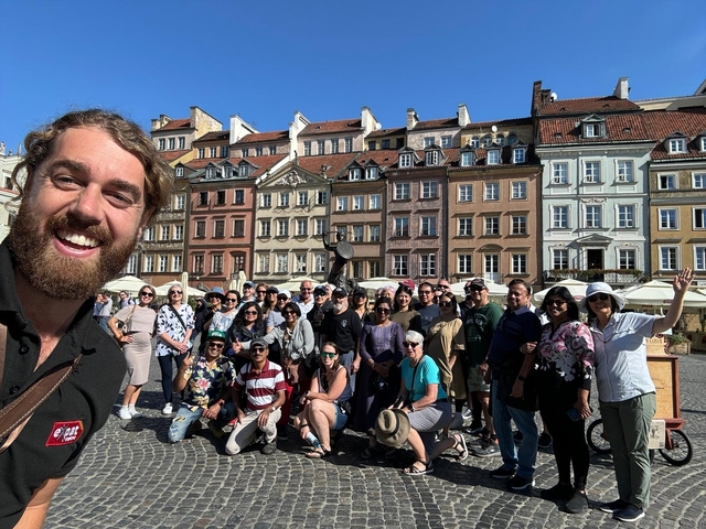 A large group of people posing in a vibrant European square.