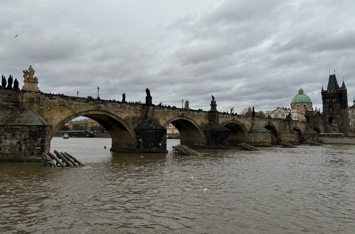Charles Bridge over Vltava River with people walking.