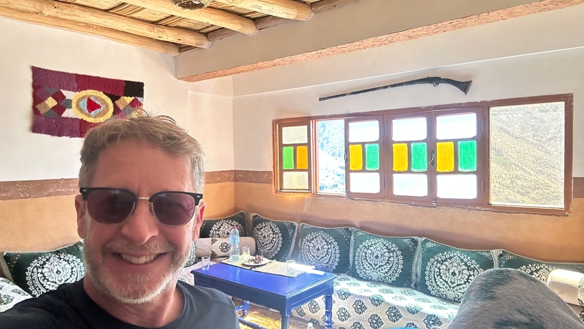 A person inside a traditionally decorated room with colorful windows.