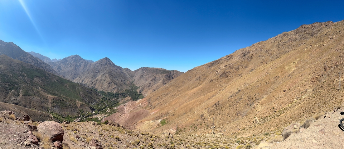 A panoramic view of a mountainous landscape under a clear blue sky.