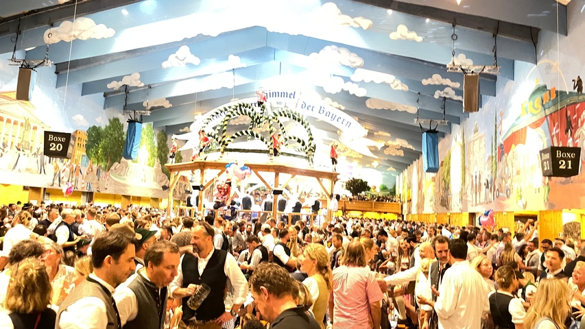 Oktoberfest beer hall with colorful ceiling and decorations.