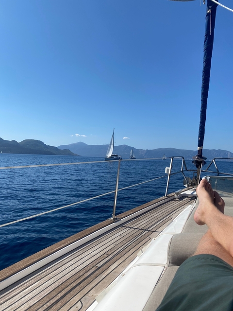 Sailboat deck with other boats visible in the distance at sea.