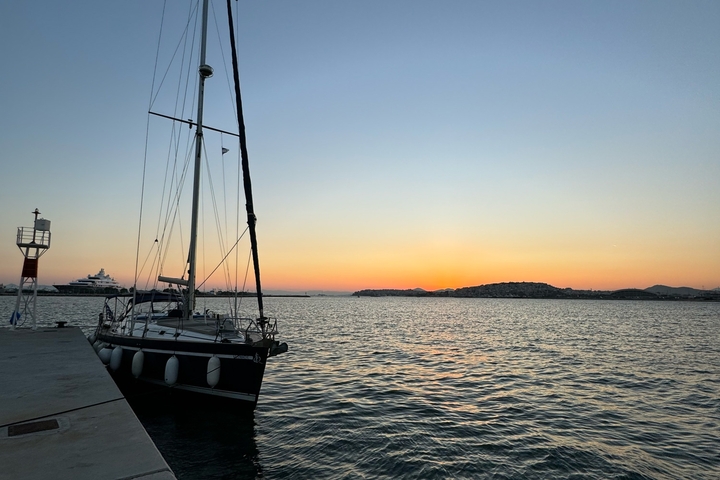 Silhouette of a sailing boat at sunset in the harbor.