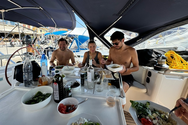 People dining on a boat with food and drinks.