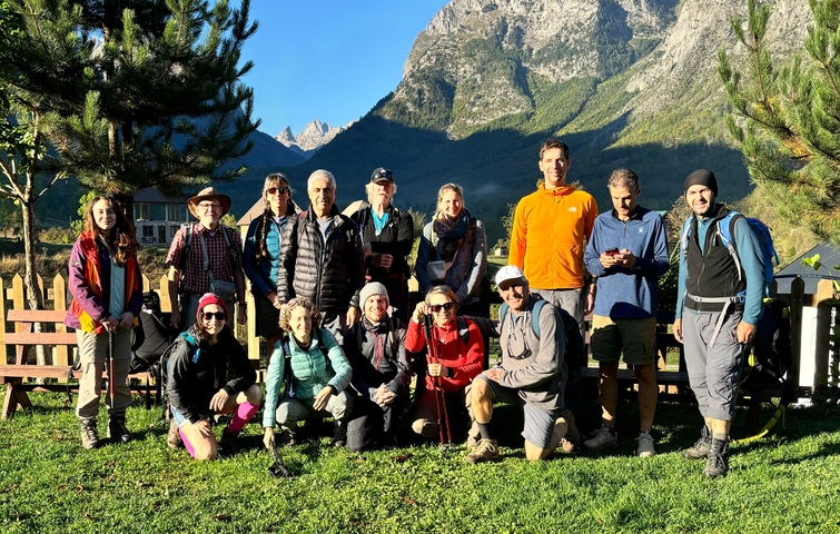 Group of hikers posing in front of mountains.