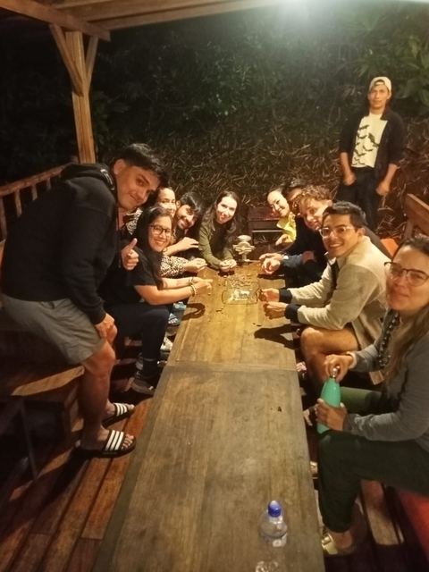 Group of people sitting around a table at night.