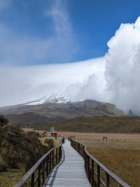 Snow-capped mountain with clouds partially covering it.